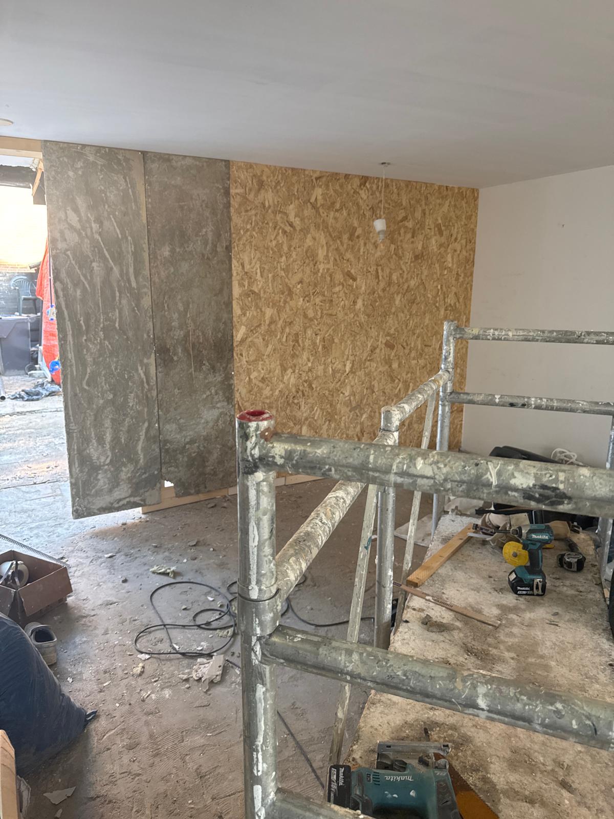 Verbouwing binnen met steiger en houten wandplaten