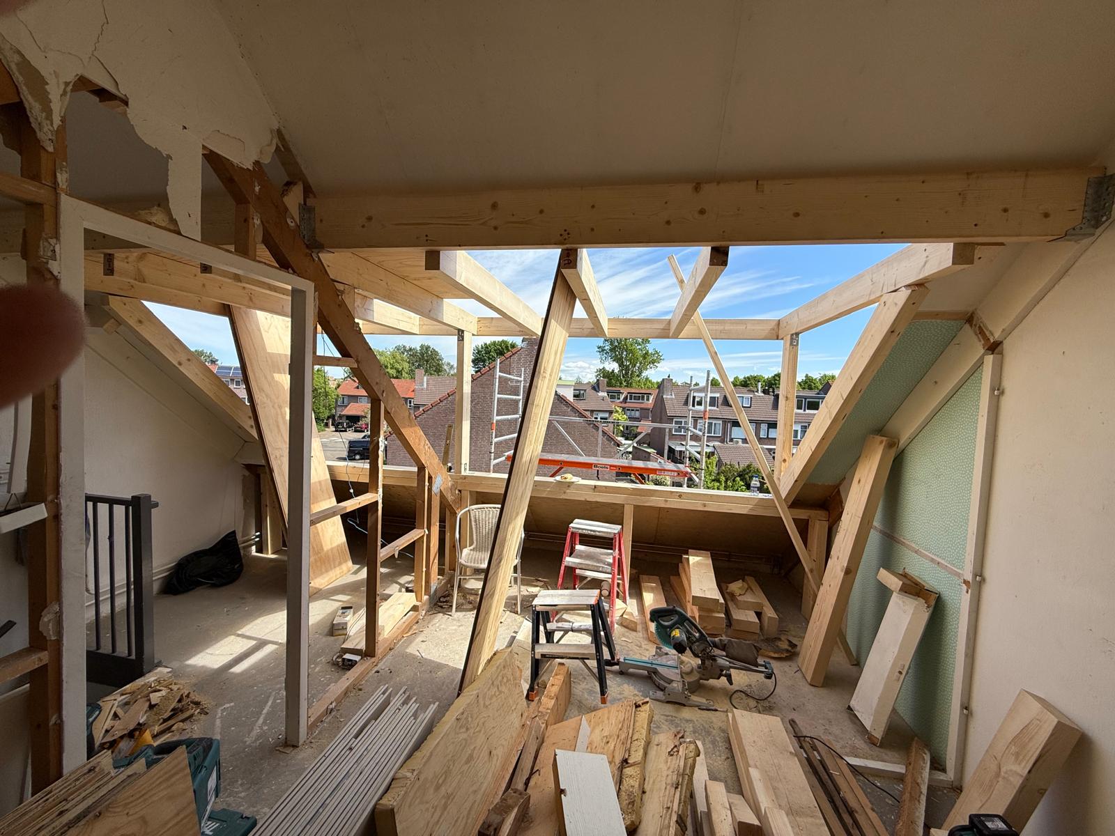 Houtskelet van een dakopbouw met zicht op omliggende daken