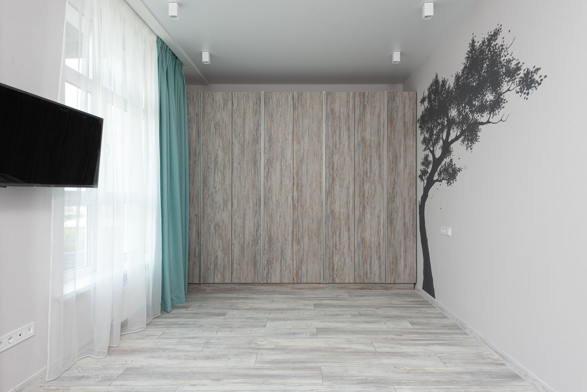 Kamer met lichtgrijze laminaatvloer en kastenwand