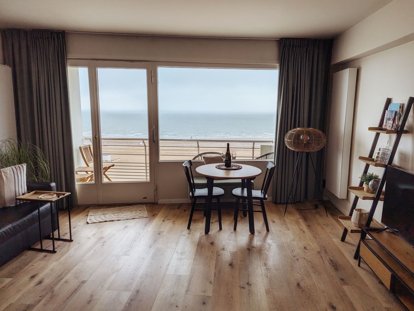 Woonkamer met eiken vloer en eettafel bij grote ramen