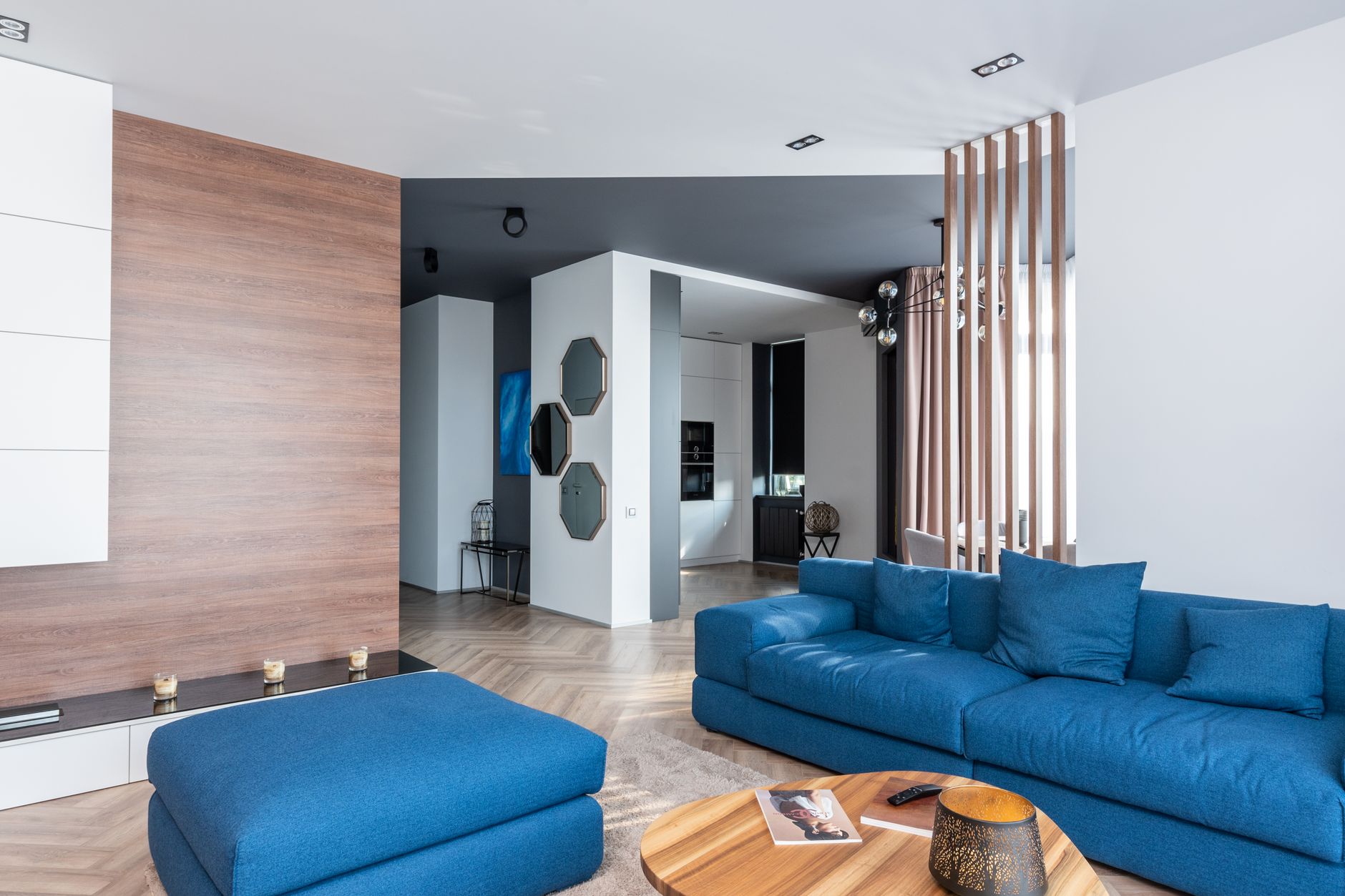 Woonkamer met blauwe bank op een visgraatvloer